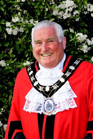 Man smiling at camera in mayoral robes and chain
