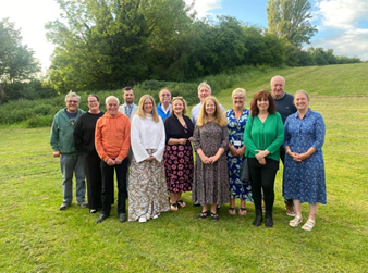 group of people stood in open space posing for picture